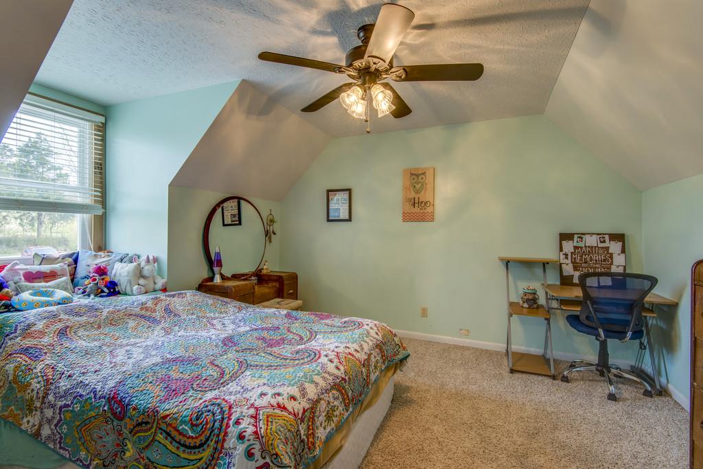 545 Haley Road Burns, TN 37029 - Photo 17 of 30 a bedroom with a bed and a chandelier