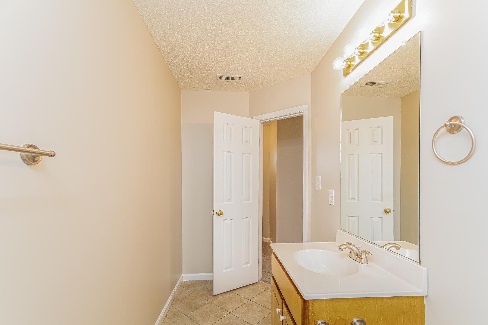 2100 McKinnon Drive Clayton, NC 27520 - Photo 17 of 17 a bathroom with a granite countertop sink a mirror and a shower