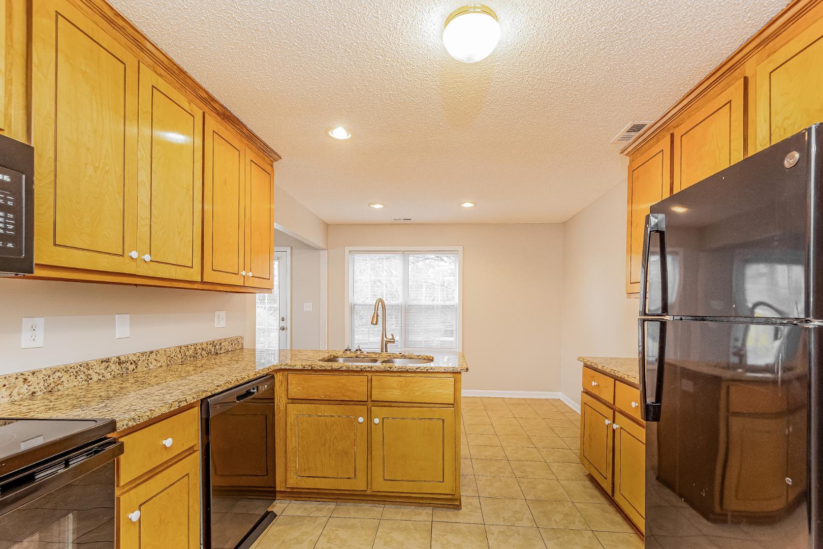2100 McKinnon Drive Clayton, NC 27520 - Photo 5 of 17 a kitchen with granite countertop a sink cabinets stainless steel appliances and a counter top space