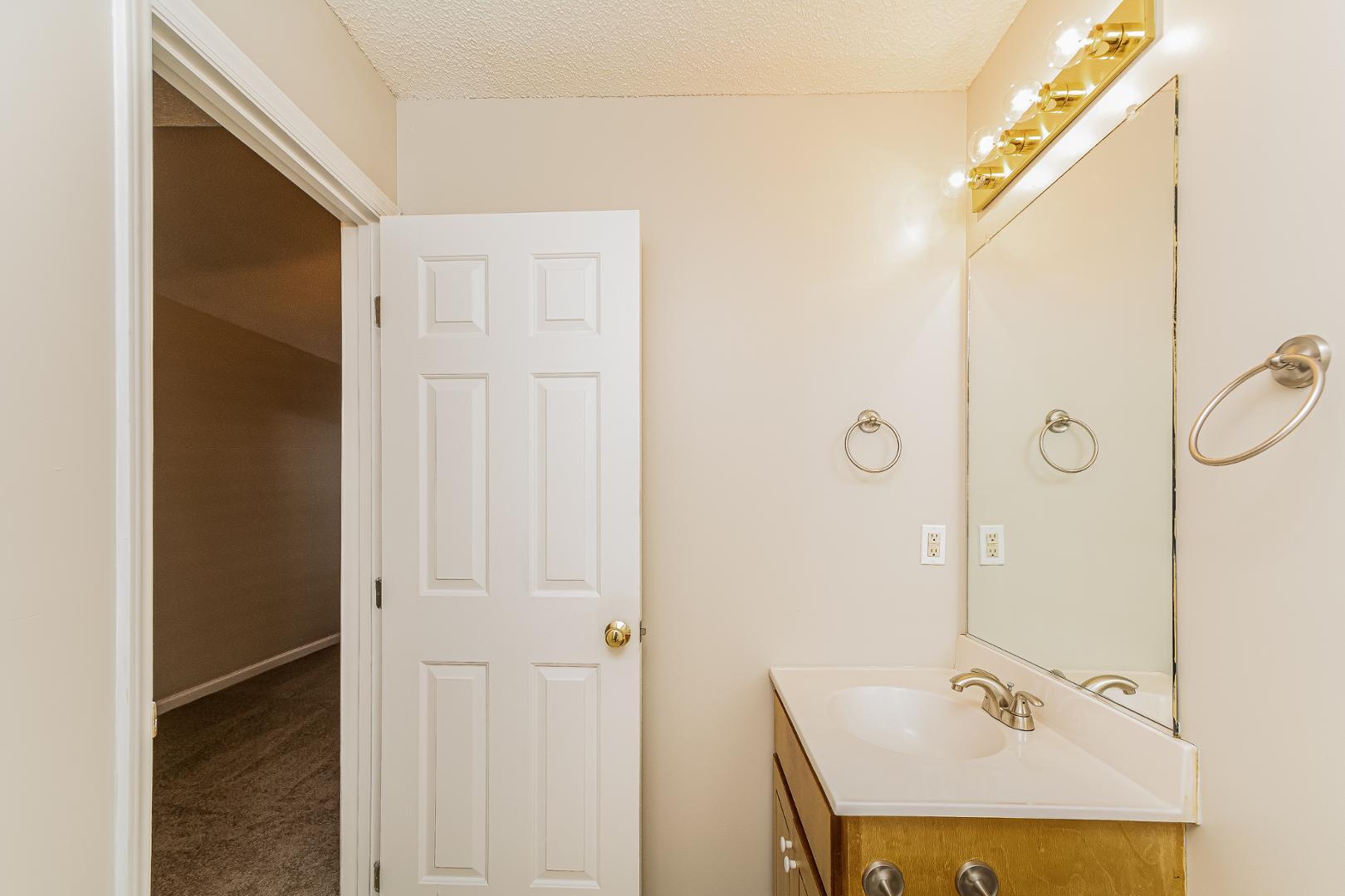 2100 McKinnon Drive Clayton, NC 27520 - Photo 9 of 17 a bathroom with a granite countertop sink a mirror and shower