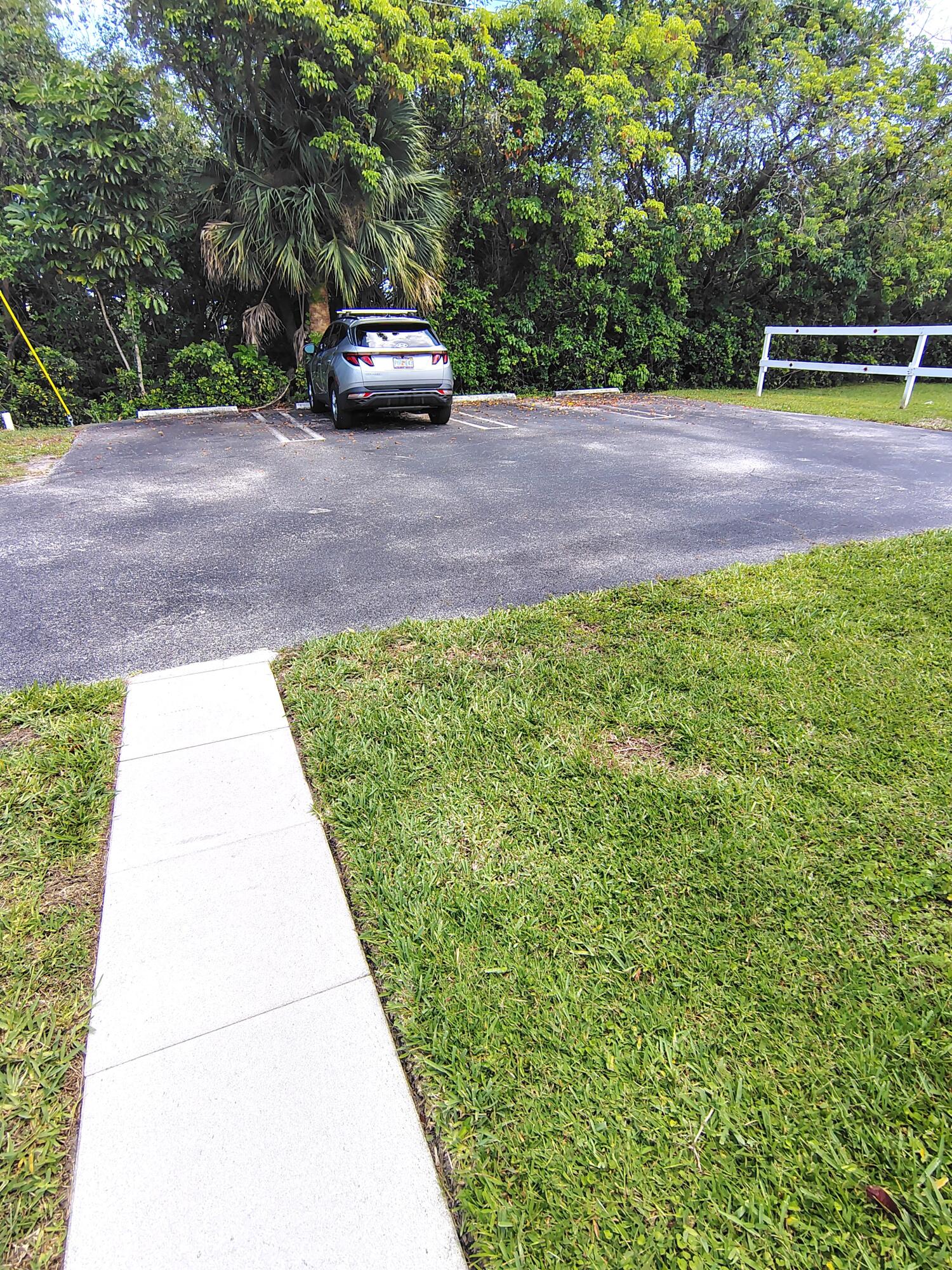 380 High Point Boulevard, Unit A Delray Beach, FL 33445 - Photo 13 of 18 a view of a yard with car parked