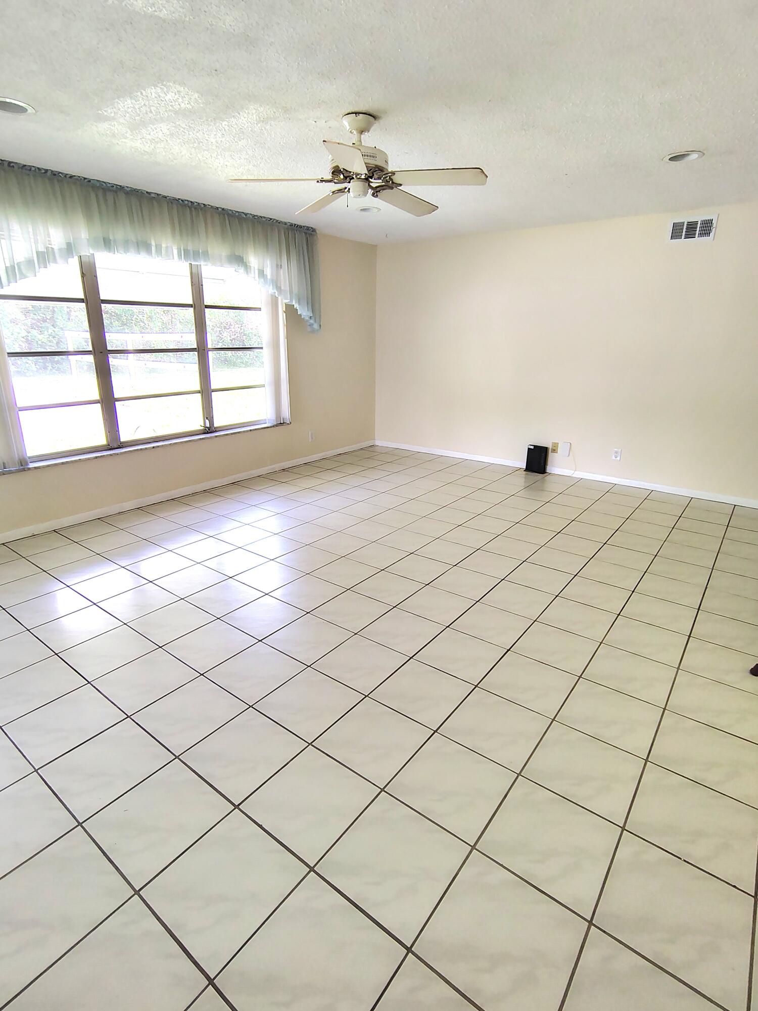 380 High Point Boulevard, Unit A Delray Beach, FL 33445 - Photo 4 of 18 a view of a livingroom with a chandelier fan and windows