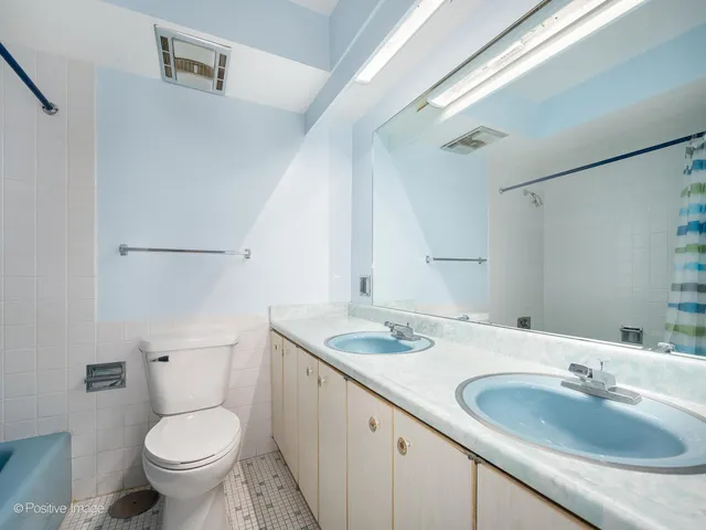 a bathroom with a granite countertop toilet a sink and a mirror