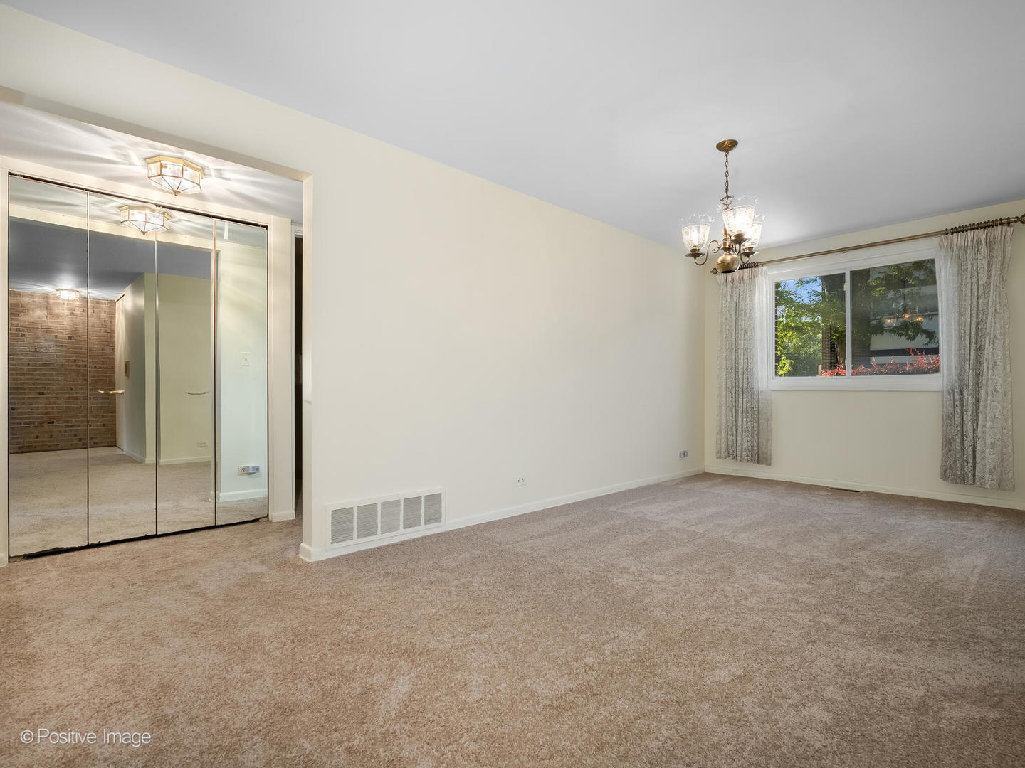 4710 Russett Lane, Unit R1 Skokie, IL 60076 - Photo 5 of 16 an empty room with chandelier and glass door