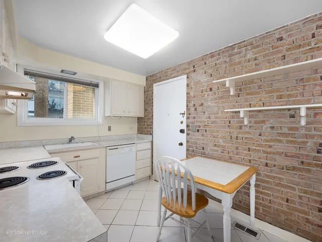 a kitchen with a sink and chairs