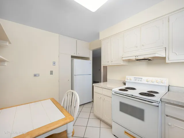 a kitchen with stainless steel appliances granite countertop a stove a refrigerator and a white cabinets