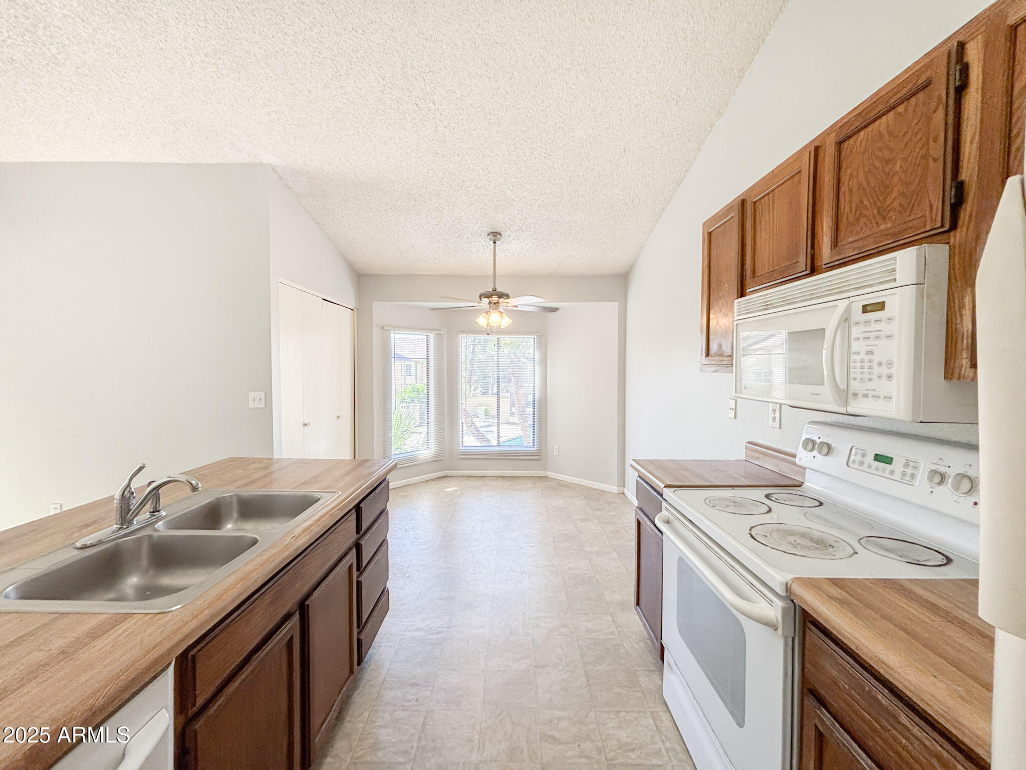 5236 West Peoria Avenue, Unit 212 Glendale, AZ 85302 - Photo 9 of 22 a kitchen with granite countertop a sink stove and cabinets