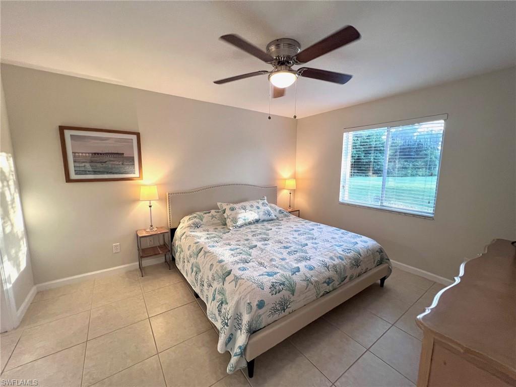 1051 Eastham Way, Unit B104 Naples, FL 34104 - Photo 16 of 23 a bedroom with a large bed and a window