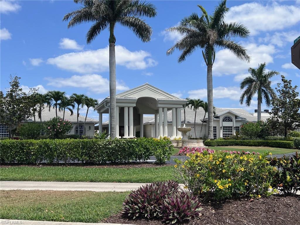 1051 Eastham Way, Unit B104 Naples, FL 34104 - Photo 18 of 23 a front view of a house with a garden and fountain