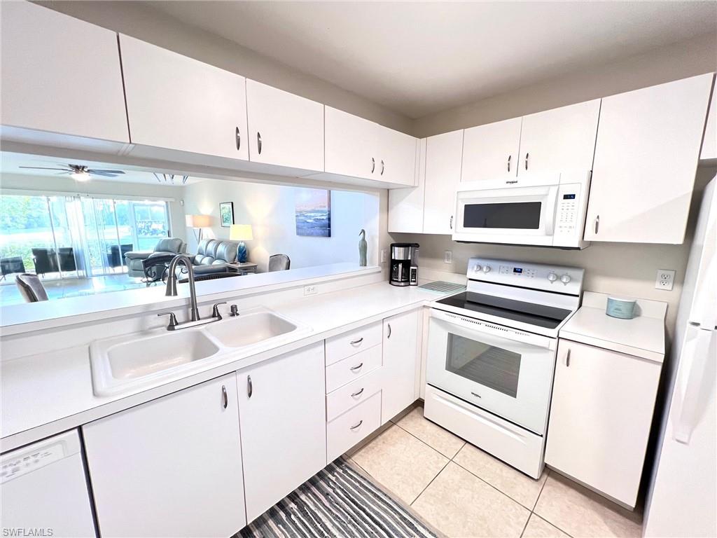 1051 Eastham Way, Unit B104 Naples, FL 34104 - Photo 9 of 23 a kitchen with appliances cabinets and a sink