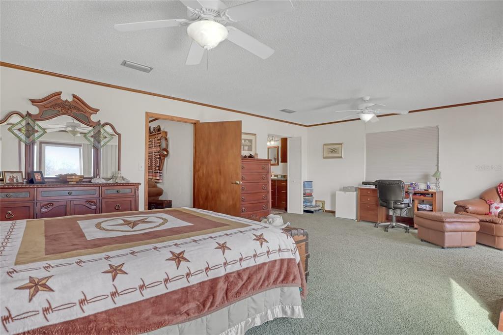 5005 Highway 1 Mims, FL 32754 - Photo 31 of 69 a spacious bedroom with a bed a chandelier and a dresser