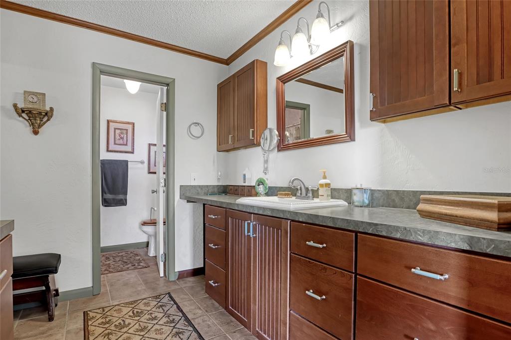 5005 Highway 1 Mims, FL 32754 - Photo 32 of 69 a bathroom with a granite countertop sink and a mirror