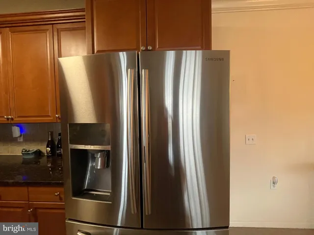 a metallic refrigerator freezer sitting in a kitchen