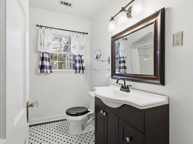 a bathroom with a sink vanity mirror and toilet