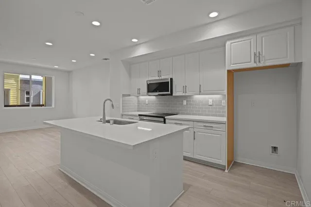 a kitchen with appliances a sink and cabinets