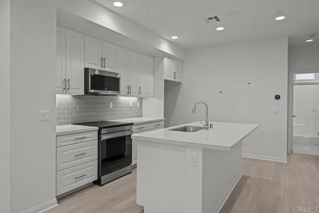 a kitchen with cabinets stainless steel appliances and sink