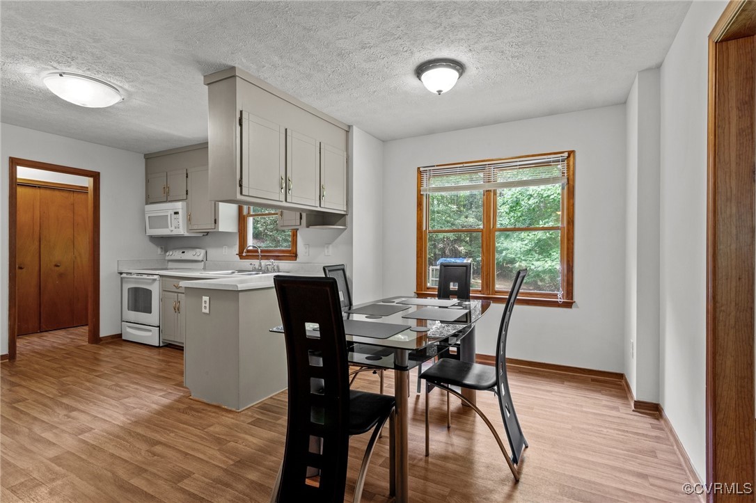 3138 Pineview Drive Powhatan, VA 23139 - Photo 21 of 46 a kitchen with stainless steel appliances granite countertop a dining table chairs stove refrigerator and cabinets
