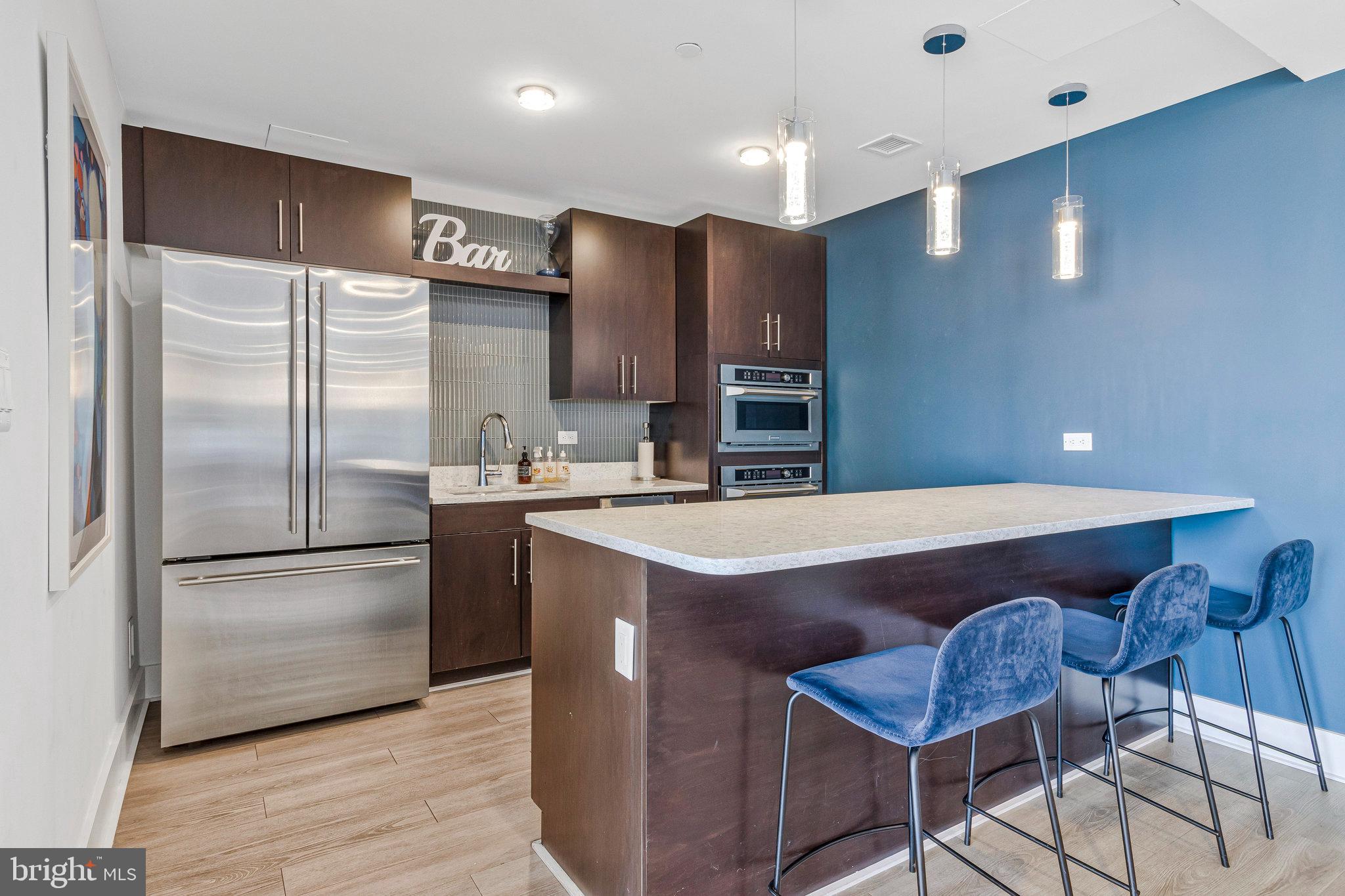 88 V Street Southwest, Unit 505 Washington, DC 20024 - Photo 15 of 38 a kitchen with kitchen island a counter top space a sink stainless steel appliances and cabinets