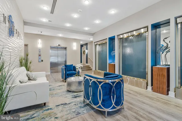 a living room with furniture a large window and wooden floor