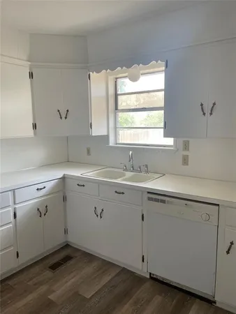 a kitchen with a sink cabinets appliances and a window