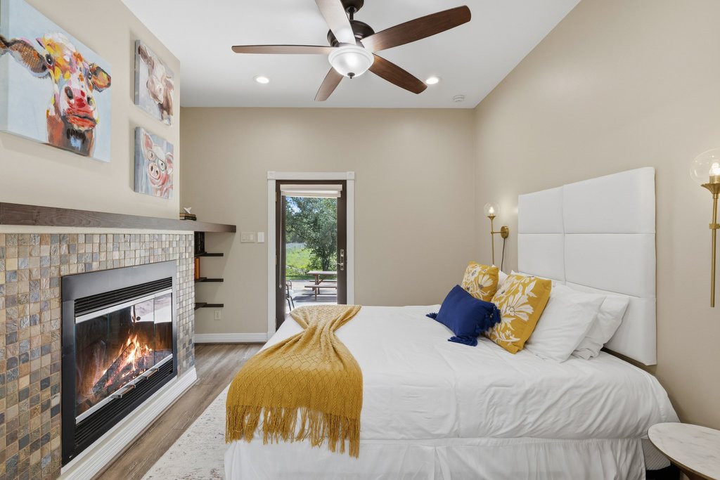 12135 Fitzhugh Road Austin, TX 78736 - Photo 13 of 30 a bedroom with a bed and a fireplace