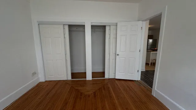 an empty room with wooden floor and closet