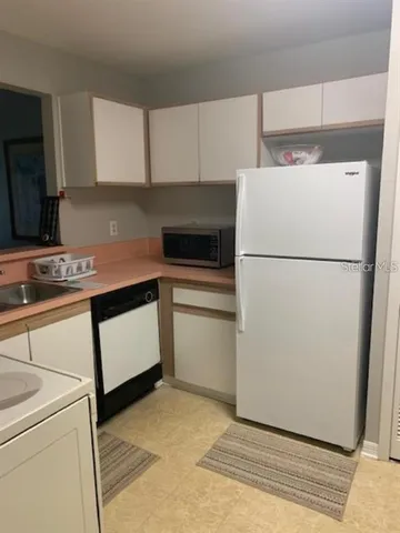 a kitchen with cabinets and white appliances