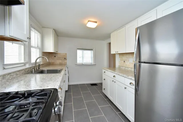 a kitchen with granite countertop a sink stove and refrigerator