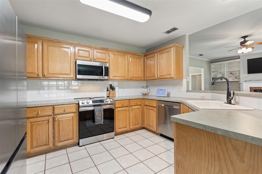 706 Maji Road Whitehouse, TX 75791 - Photo 13 of 37 a kitchen with stainless steel appliances granite countertop a stove top oven a sink dishwasher and a microwave oven on the blue kitchen countertops