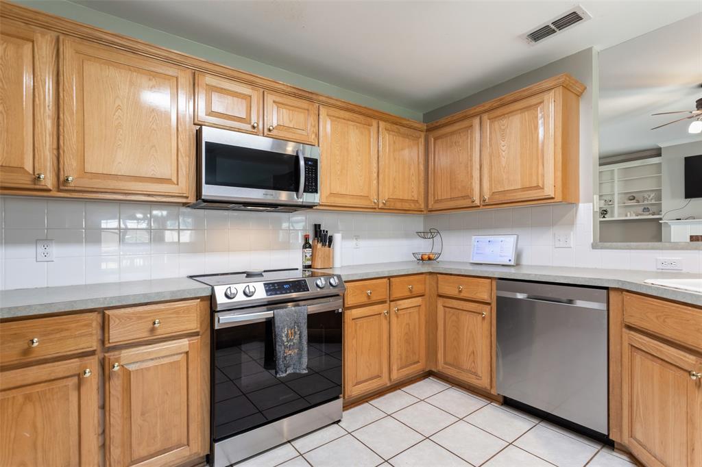 706 Maji Road Whitehouse, TX 75791 - Photo 14 of 37 a kitchen with granite countertop cabinets stainless steel appliances and a window