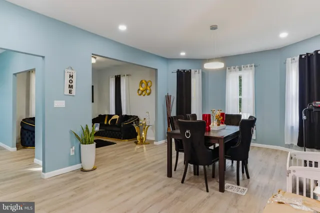 a living room with furniture a large window and a dining table