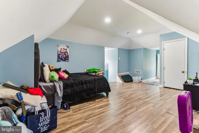 a bedroom with bed and a wooden floor