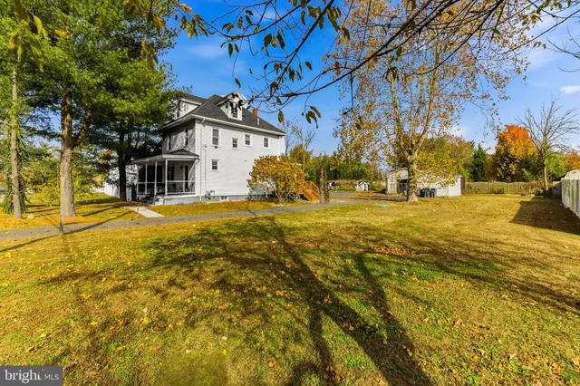 a view of a house with pool and trees in front of it