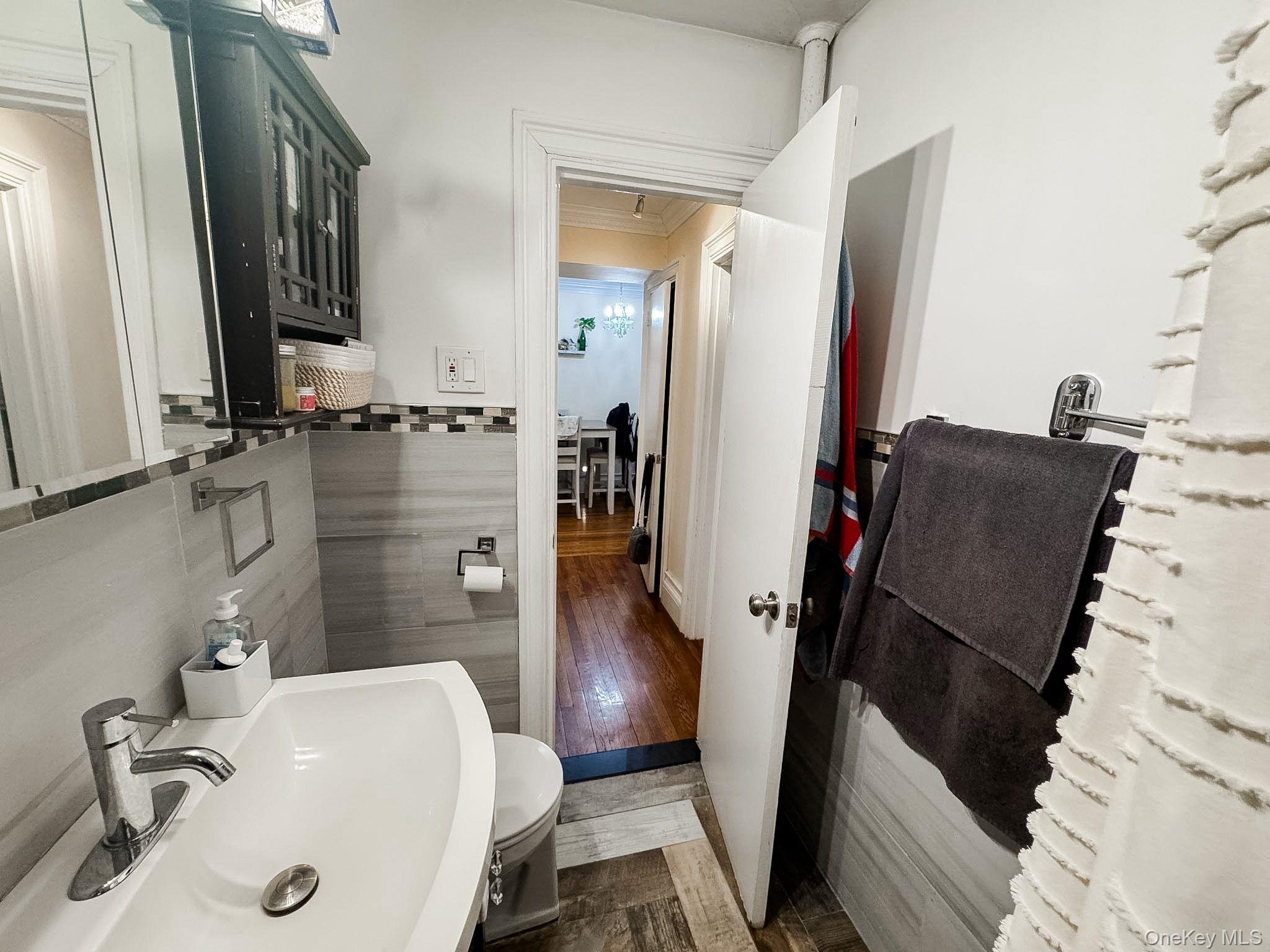 83-25 98th Street, Unit 1P Queens, NY 11421 - Photo 11 of 16 a bathroom with a sink and mirror with bathtub