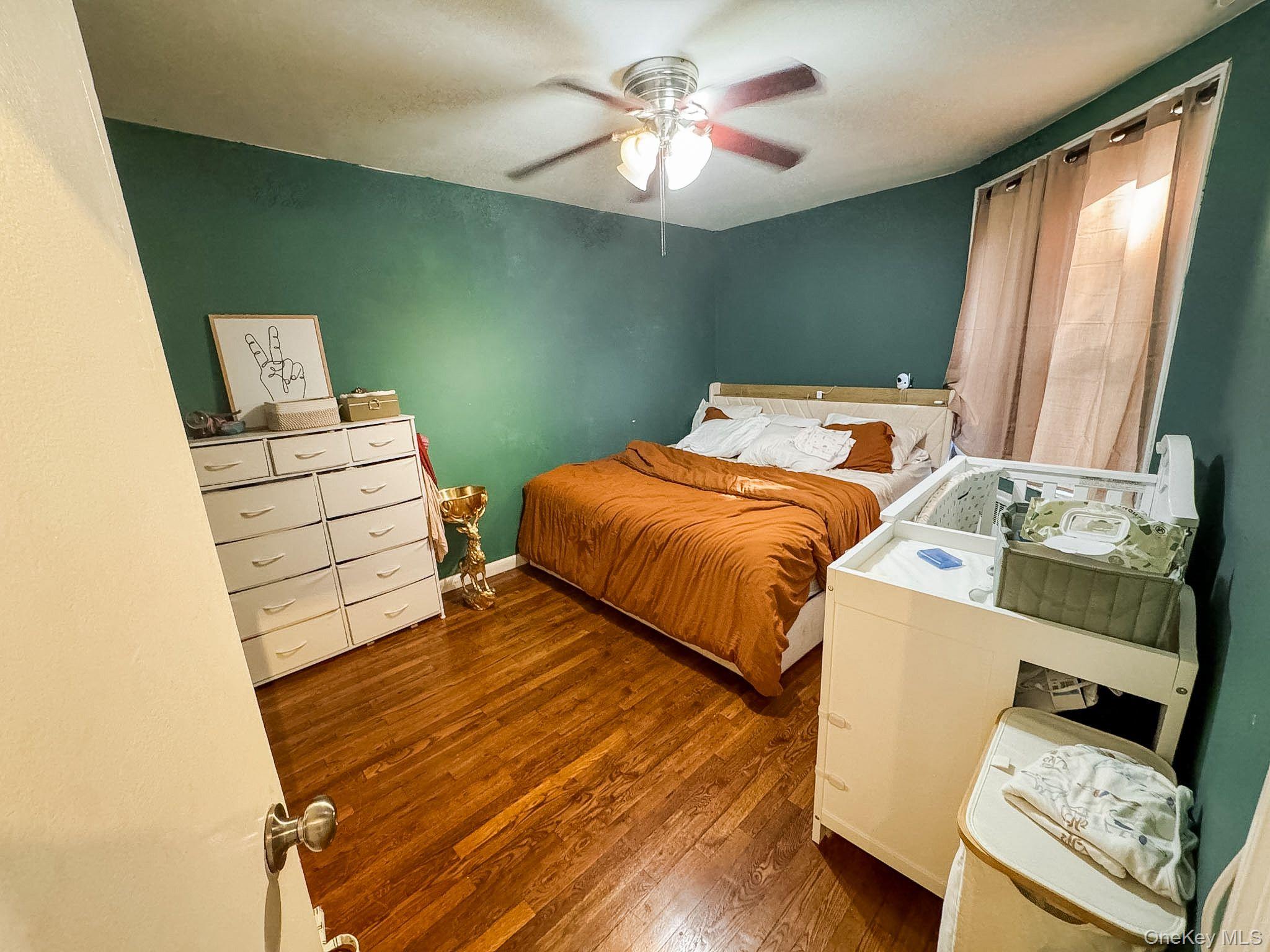 83-25 98th Street, Unit 1P Queens, NY 11421 - Photo 12 of 16 a bedroom with a bed and a chandelier