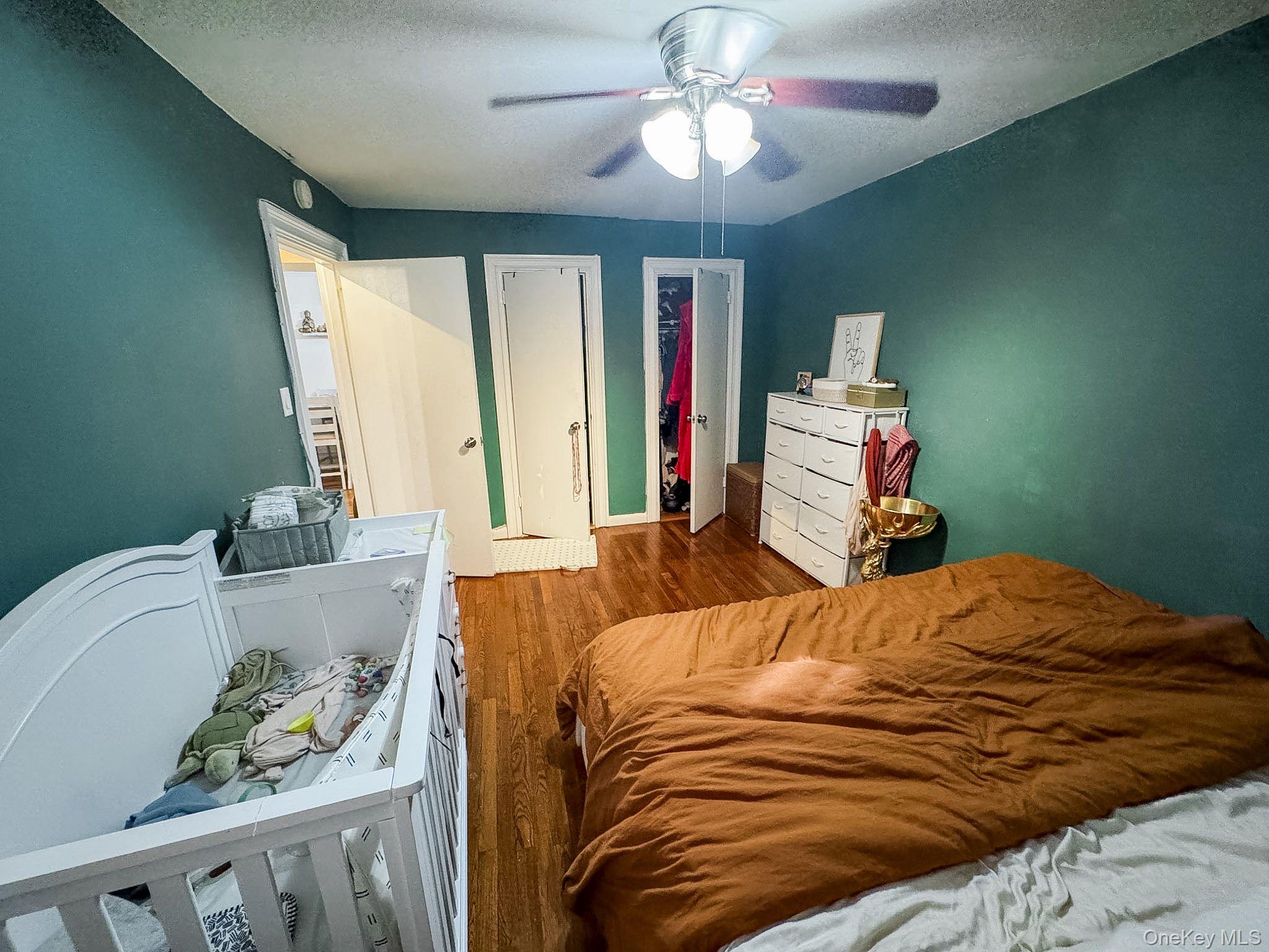 83-25 98th Street, Unit 1P Queens, NY 11421 - Photo 13 of 16 a bedroom with a bed and a chandelier