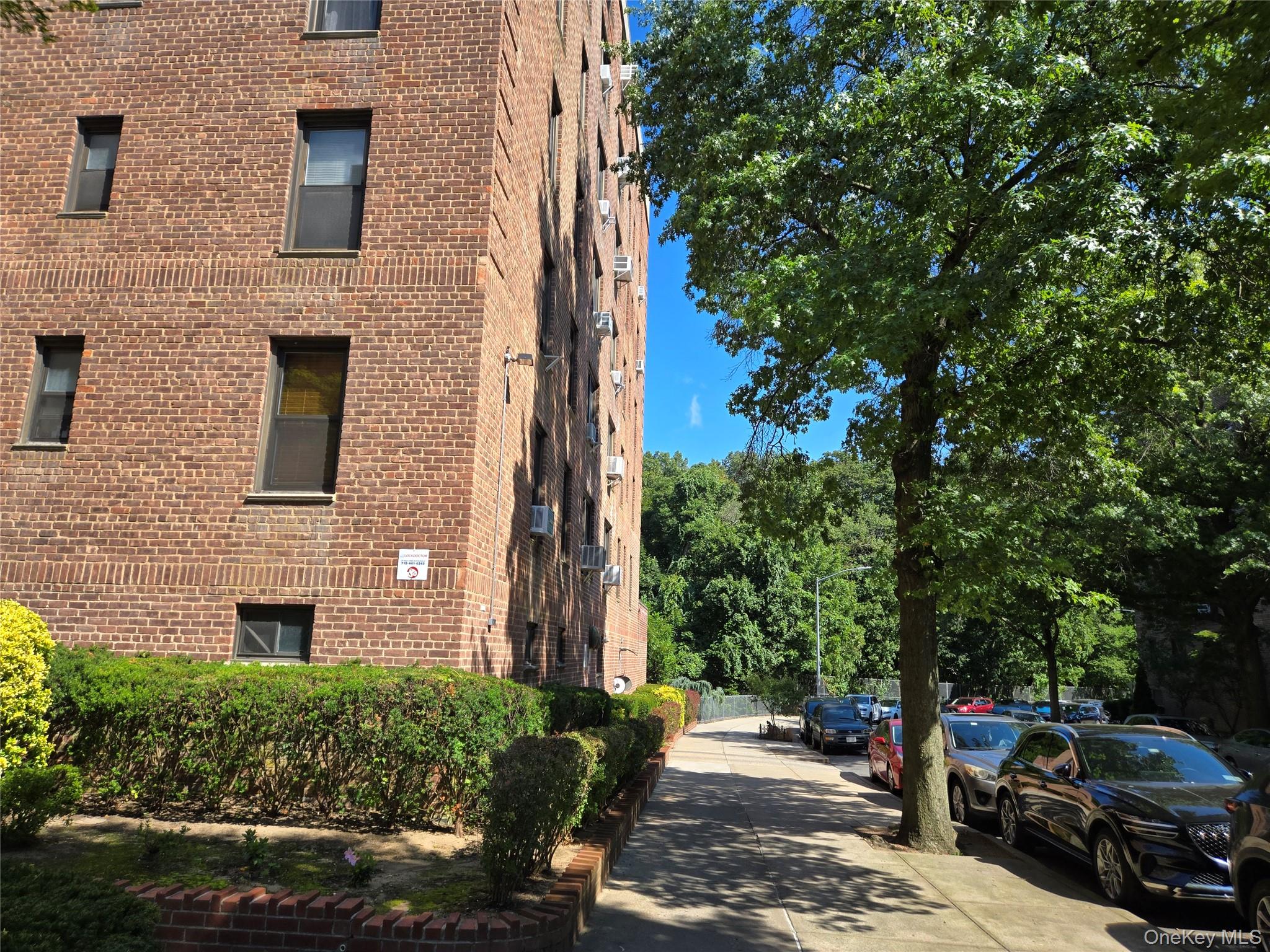 83-25 98th Street, Unit 1P Queens, NY 11421 - Photo 3 of 16 a couple of cars parked in front of brick building