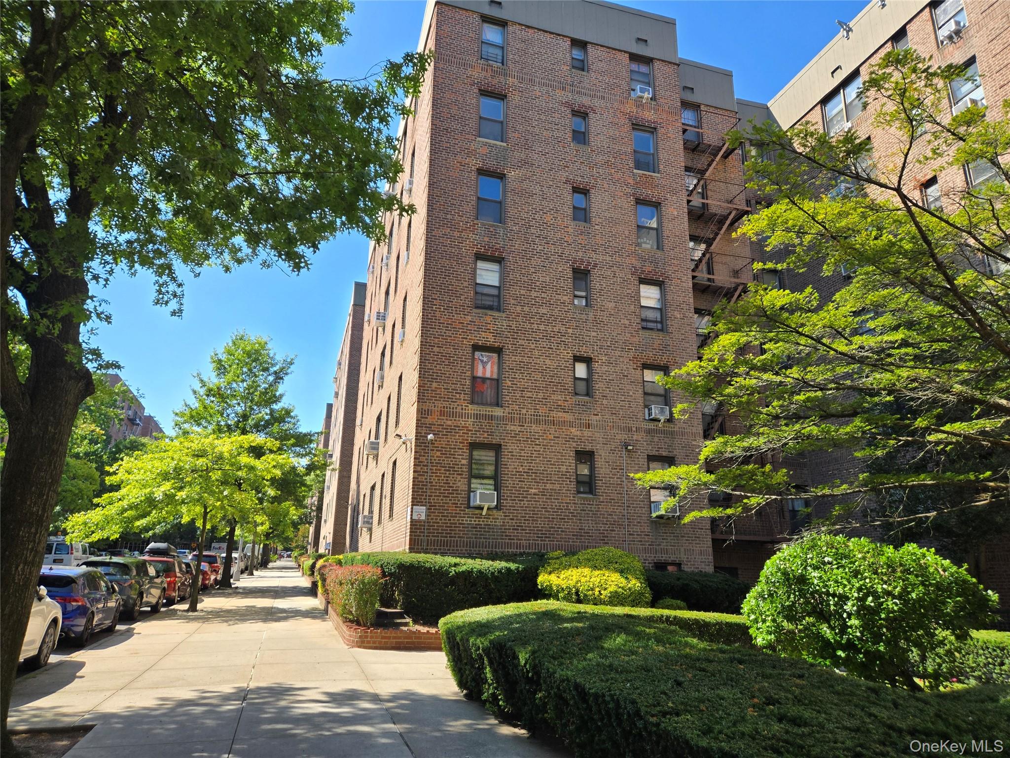 83-25 98th Street, Unit 1P Queens, NY 11421 - Photo 4 of 16 a view of a tall brick building next to a yard
