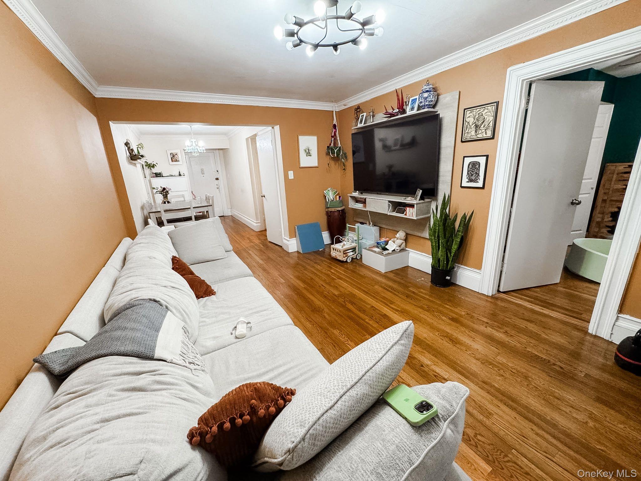 83-25 98th Street, Unit 1P Queens, NY 11421 - Photo 5 of 16 a living room with furniture and a flat screen tv