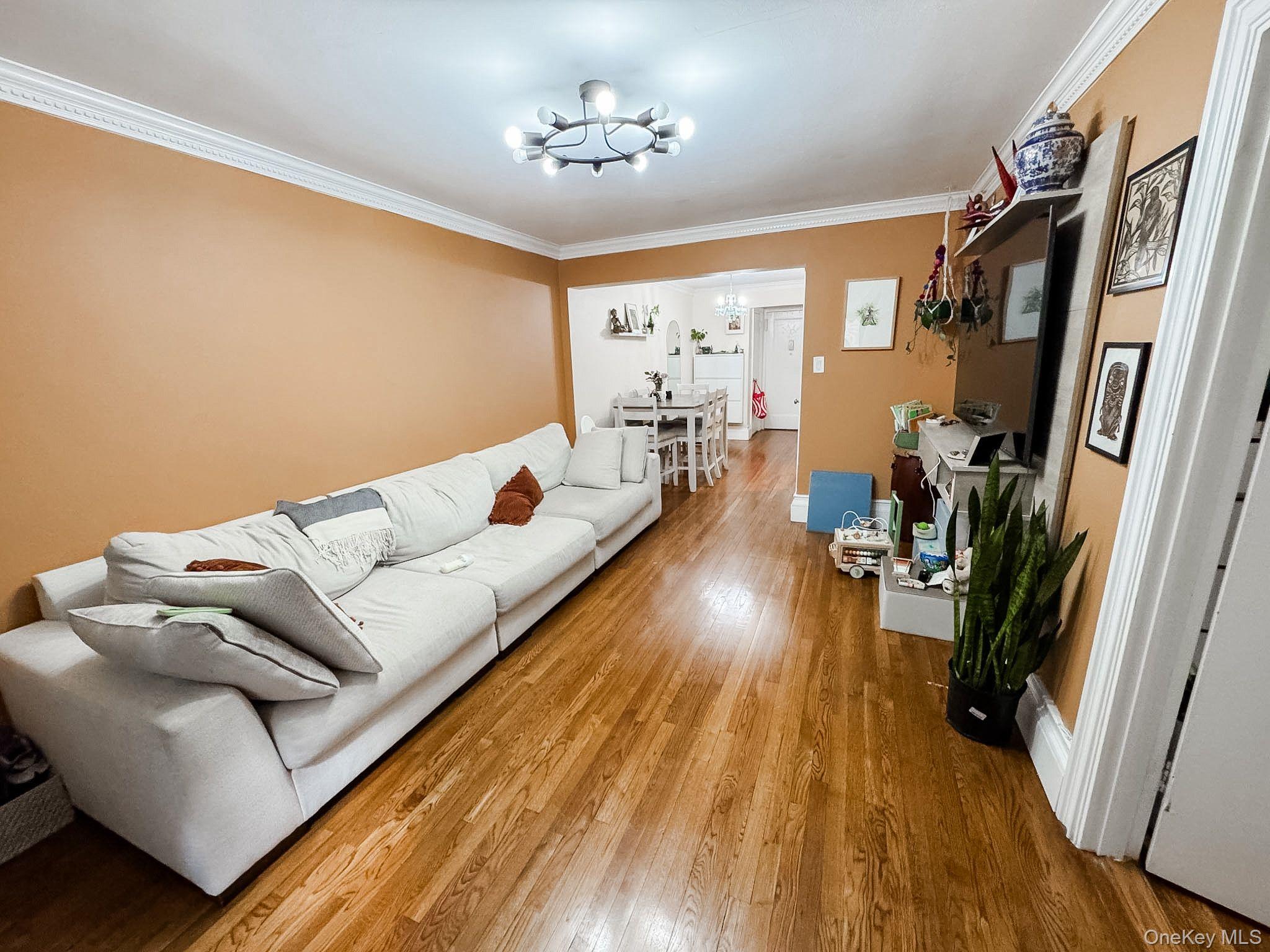 83-25 98th Street, Unit 1P Queens, NY 11421 - Photo 6 of 16 a living room with furniture and a wooden floor