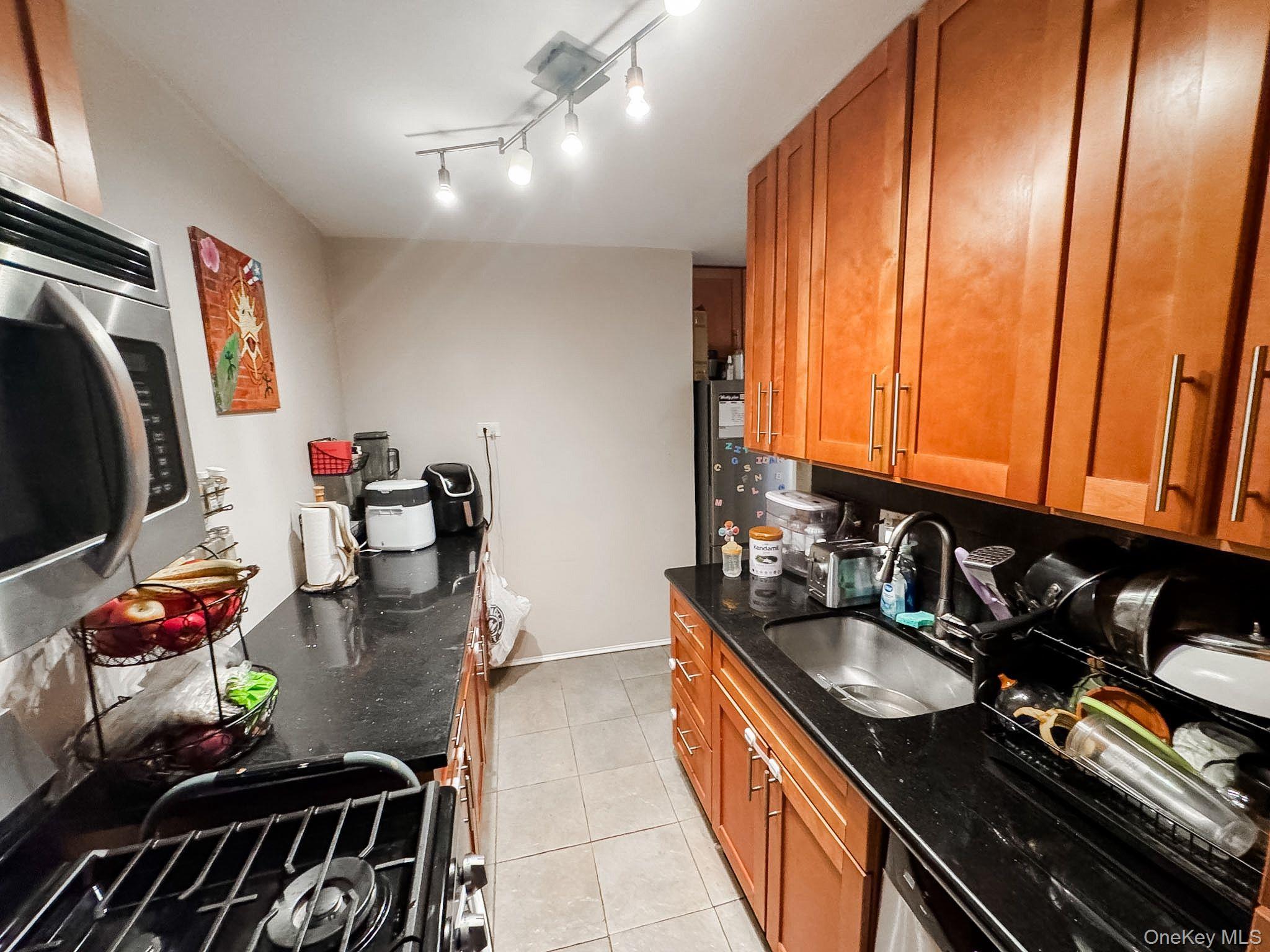 83-25 98th Street, Unit 1P Queens, NY 11421 - Photo 8 of 16 a kitchen with sink refrigerator and stove