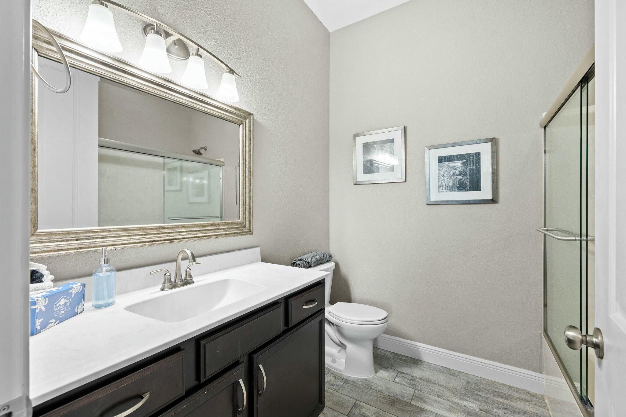4596 Paradise Isle Destin, FL 32541 - Photo 16 of 60 a bathroom with a sink a toilet and a mirror