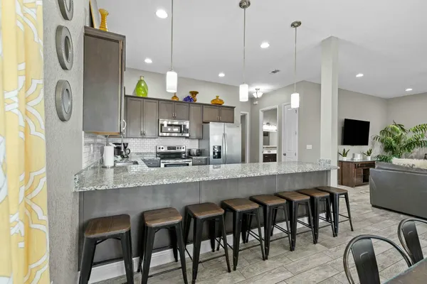a kitchen with stainless steel appliances granite countertop a refrigerator and a stove