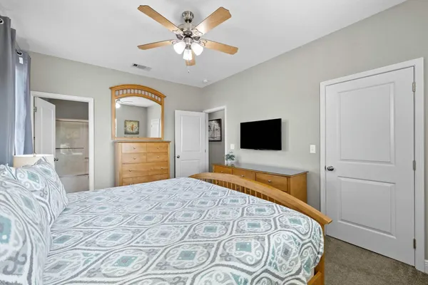 a bedroom with a bed and a ceiling fan