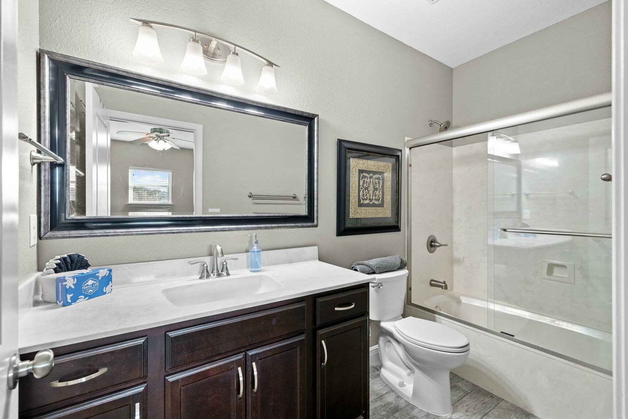 4596 Paradise Isle Destin, FL 32541 - Photo 44 of 60 a bathroom with a sink a toilet a mirror and shower
