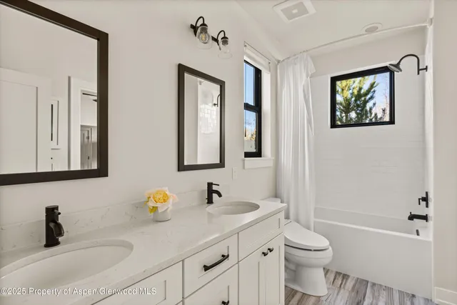 a bathroom with a toilet a sink a tub and mirror