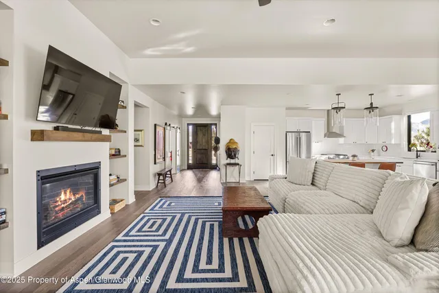 a living room with furniture a flat screen tv and a fireplace