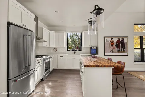 a kitchen with stainless steel appliances granite countertop a refrigerator sink and stove