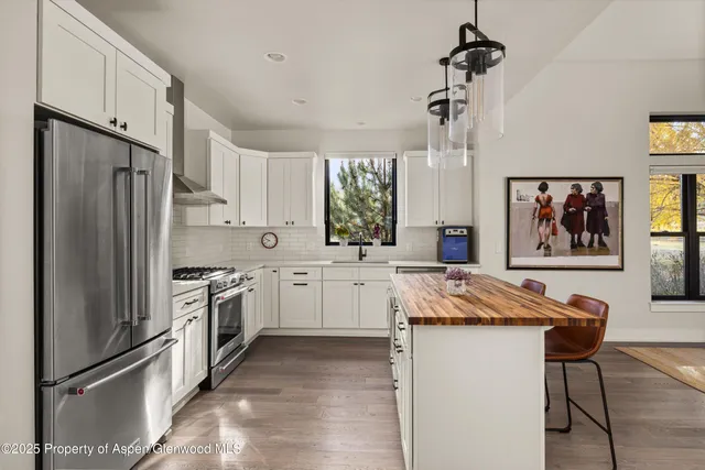 a kitchen with stainless steel appliances granite countertop a refrigerator sink and stove
