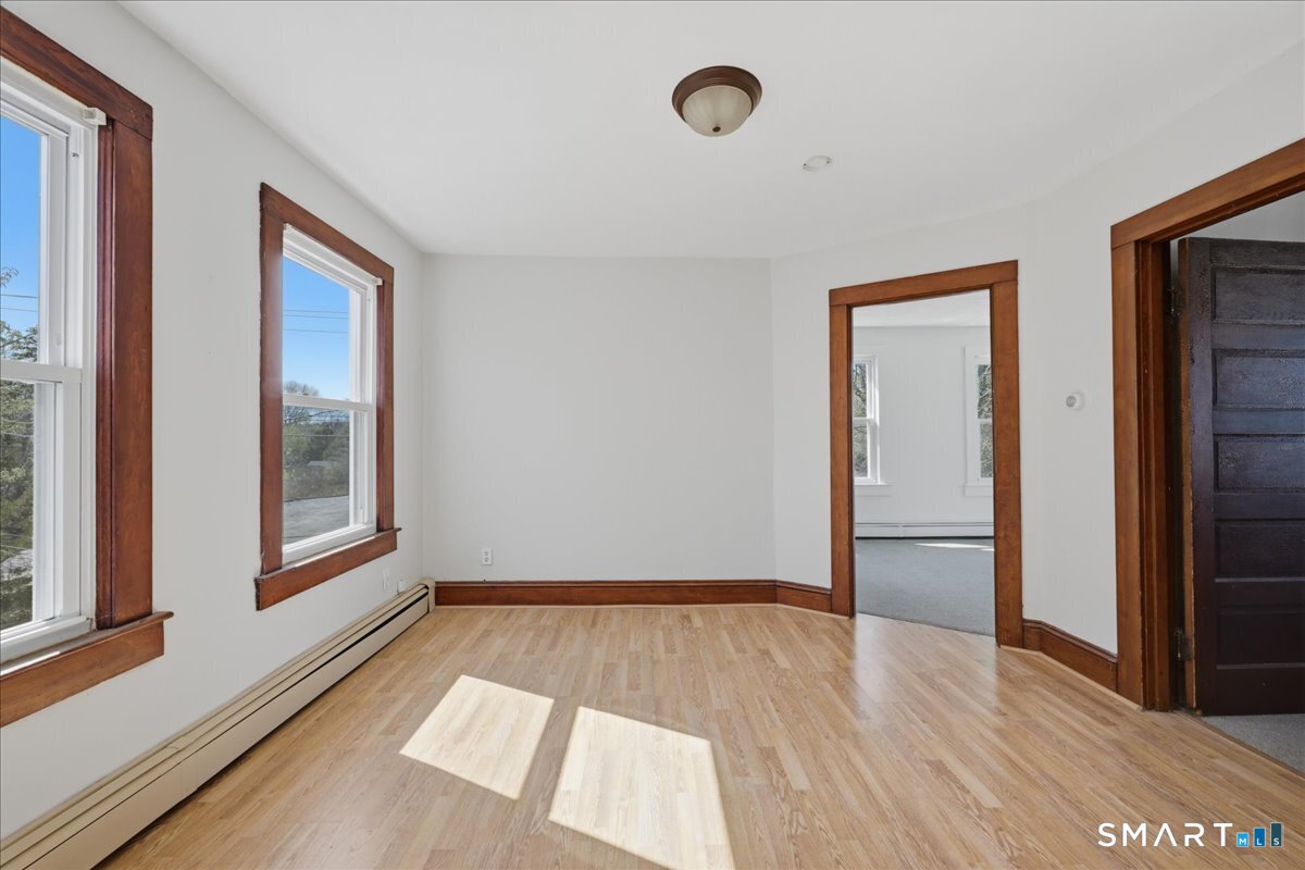 46 Hatch Street Stonington, CT 06355 - Photo 14 of 40 a view of an empty room with wooden floor and a window
